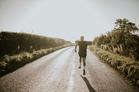 Man running in the countryside at sunset rear view