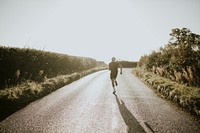 Man running in the countryside at sunset rear view