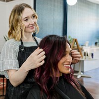 Hairstylist giving a finishing touch to customer at a beauty salon