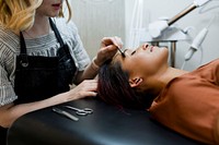 Beautician giving eyebrow treatment to a customer at a beauty salon