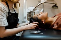 Beautician giving eyebrow treatment to a customer at a beauty salon