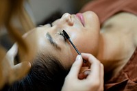 Beautician giving eyelash treatment to a customer at a beauty salon