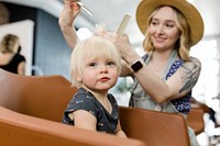 Hairstylist giving a little kid a haircut 