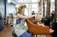 Hairstylist giving a little kid a haircut