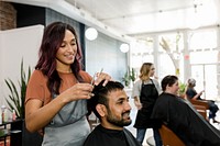 Man getting a haircut from a hair stylist at a barber shop 