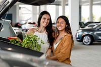 Lesbian couple grocery shopping, putting stuff in car trunk