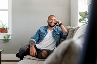 Man on phone call, sitting on a couch at home