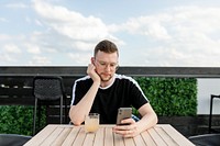 Man using a mobile phone, while having coffee at a cafe