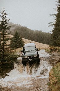 Off-roading car stuck in the water stream in nature