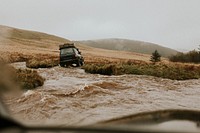 Off-roading car stuck in the water stream in nature