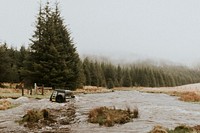 Off-roading car stuck in the water stream in nature