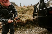 Man connecting the car towing cable 