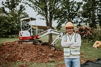 Civil engineer standing by an excavator outdoors 