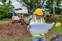 Construction worker reading a floor plan at the site 