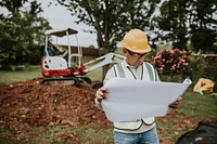 Middle aged contractor reading the floor plan at the site