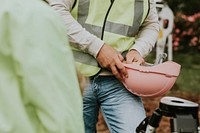 Construction worker with safety vest holding a hardhat
