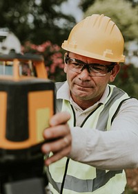 Civil engineer using a land surveying tool