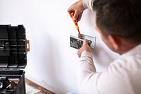 Electrician fixing the power outlet on the wall