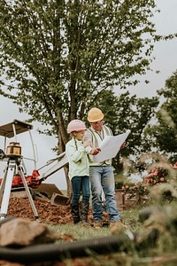 Father and daughter working at construction site