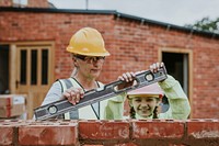 Contractor mother teaching daughter construction work