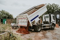 Dump truck unloading soil on a construction site