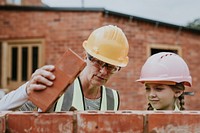 Mother teaching kid how to lay bricks