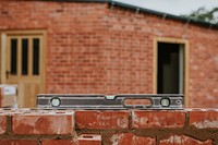 Spirit level on laid bricks wall outside the house