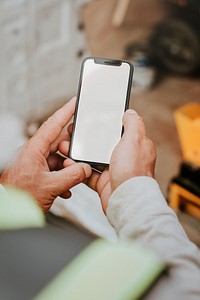 Man holding blank smartphone near a construction site