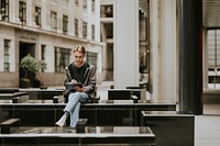 Man sitting and using a digital tablet in the city 