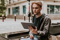 Man sitting and using a digital tablet in the city 