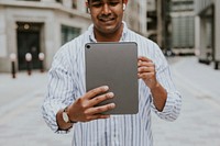 Man having a video call on his digital tablet in a city 