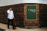 Wooden frame mockup psd on a brick wall with a man passing by