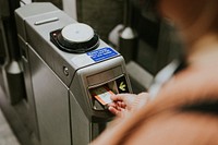 Person inserting a train ticket into a turnstile 