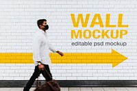 Wall mockup psd with a man walking past in the new normal 