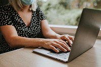 Woman  wearing mask using laptop on a train in the new normal