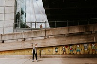 Woman taking a selfie by a street art mural graffiti by UK artist Stik at South Bank, Waterloo, London, United Kingdom taken on 22 June 2021