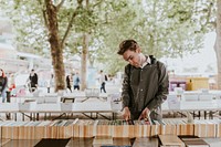 Man browsing secondhand books at street side used bookshop 