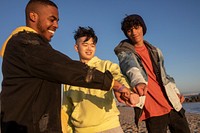 Hands together, best friends teen boys on the beach