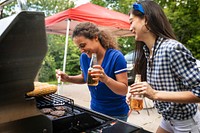 Girls grilling burgers at a tailgate party