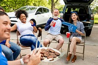 Man handing out burgers at a tailgate party