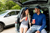 Baseball fans sitting in car boot at a tailgate party