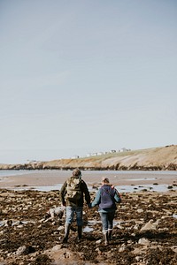 Tourist couple walking on the beach in the countryside