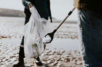 Beach cleanup volunteers picking up trash for environment campaign