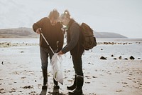 Beach cleanup volunteers picking up trash for environment campaign