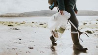 Beach cleanup volunteer carrying garbage bag for environment campaign