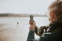 Senior woman using smartphone digital device screen with design space