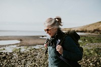 Senior tourist woman walking at the beach