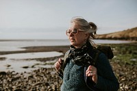 Senior tourist woman walking at the beach