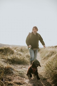 Senior man walking his dog on a coastal trail