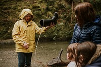 Woman pouring out water out of wellington boot in the forest